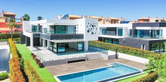 a large white house with a pool in front of it