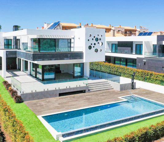 a large white house with a pool in front of it